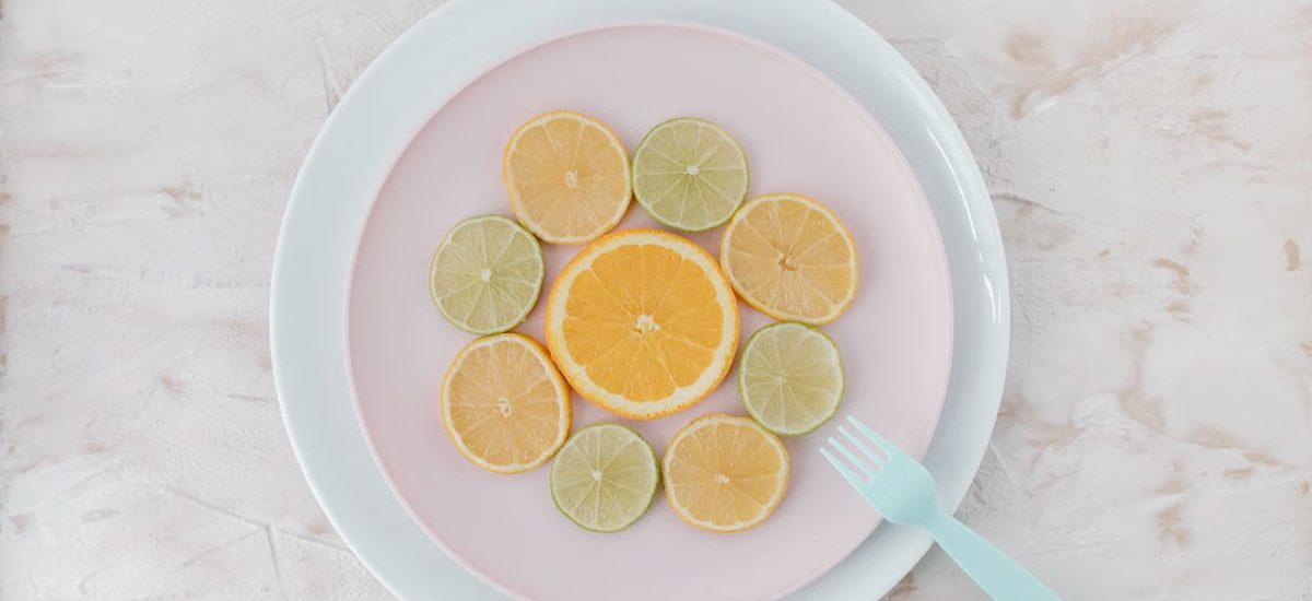 Top view of citrus slices on ceramic plates, showcasing lime and orange artistry.