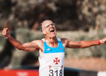 Glad senior male runner with arms outstretched and mouth opened rejoicing success in running competition